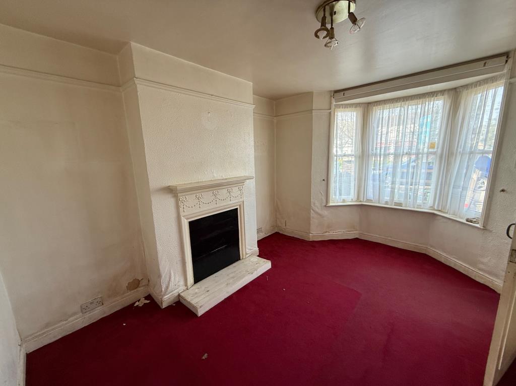 Lot: 90 - ESTABLISHED MID-TERRACE HOUSE FOR IMPROVEMENT - Living room with fireplace and bay window to the front